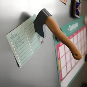 3D axe and knife shaped magnetic fridge decorations attached to a refrigerator door