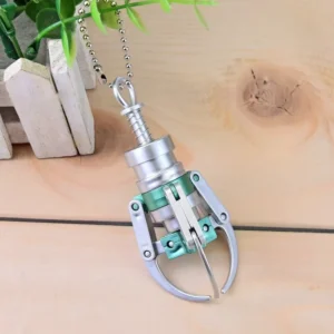 Miniature keychain pendant styled like a claw machine with a small claw and protective casing