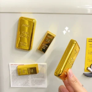 Gold bar shaped refrigerator magnet with integrated beer bottle opener on white background