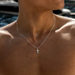 Minimalist cross pendant necklace hanging on black chain