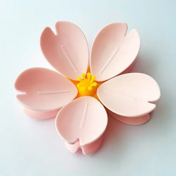 Set of two pink Sakura magnetic snack bag clips with petal design on fridge surface
