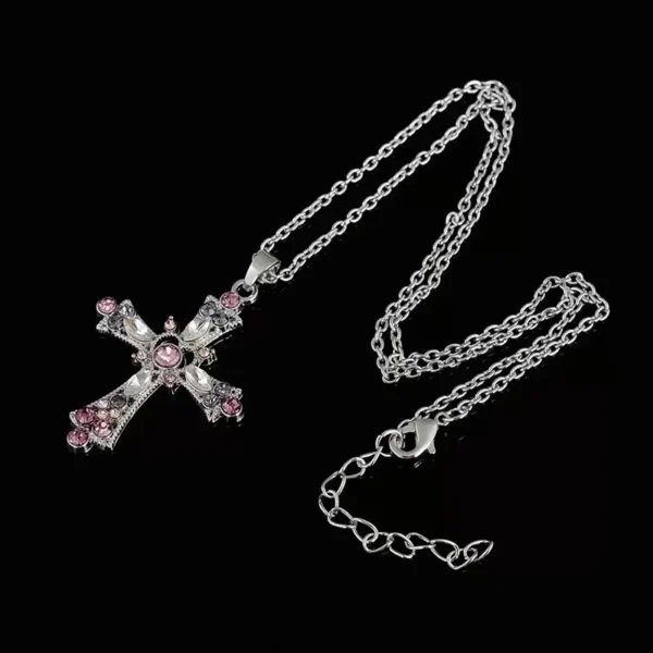 Pink crystal heart cross pendant necklace with silver clavicle chain on white background