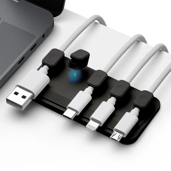 Magnetic plastic cable clip holding a USB charging cable on a desk